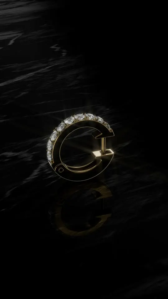 Arete dorado con diamantes sobre mármol negro